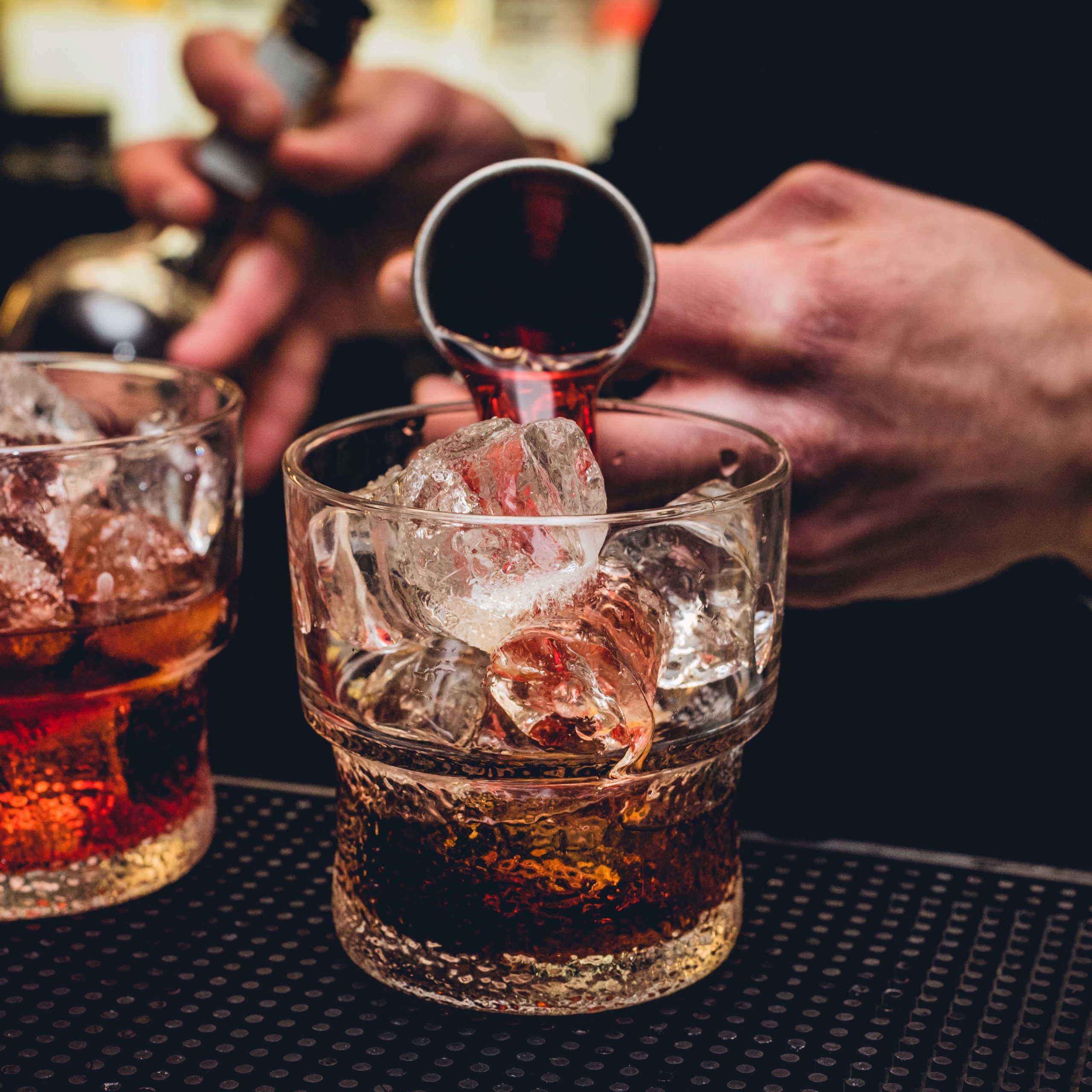 Bartender versa vermut rosso nel bicchiere mentre prepara un Ame